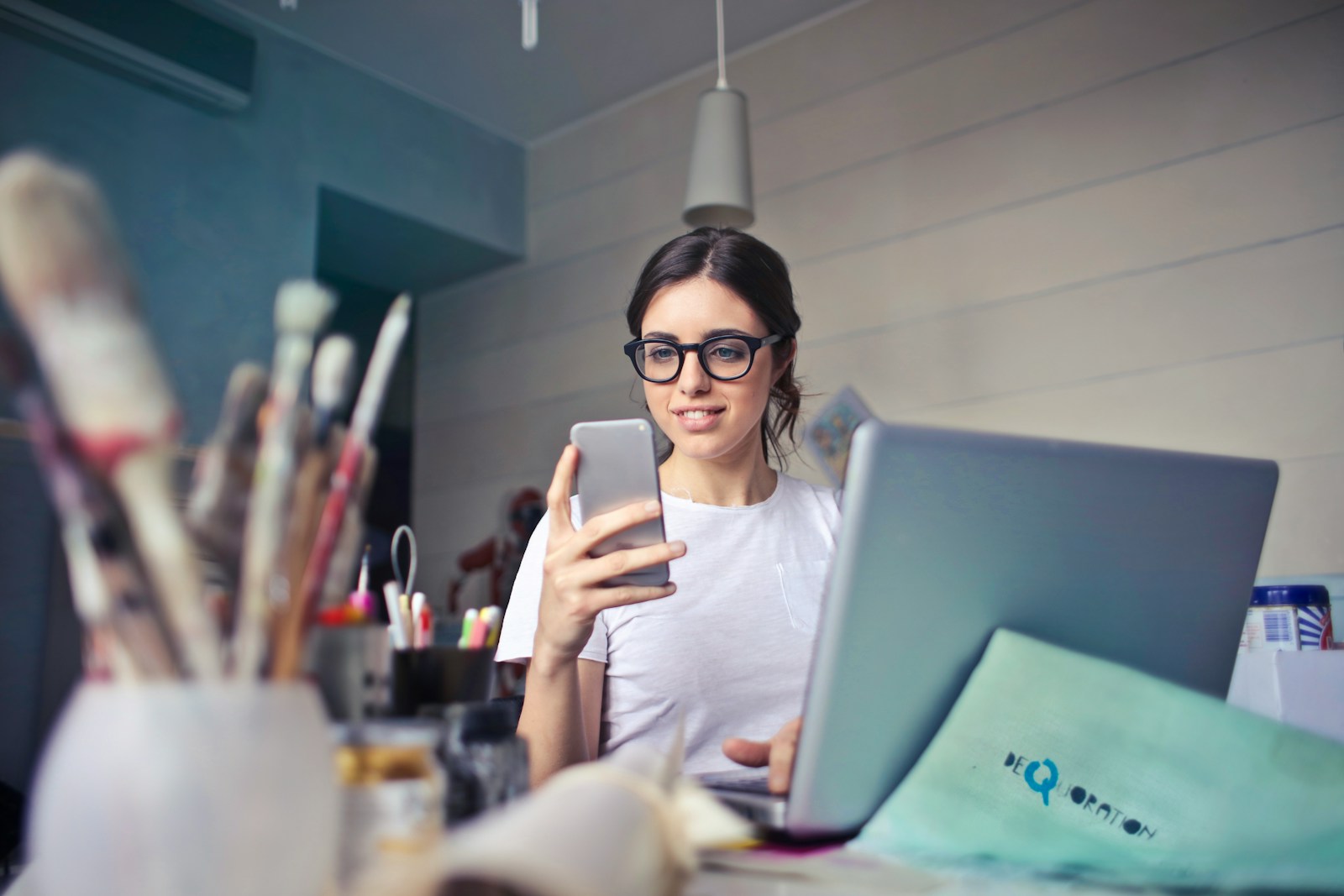 woman in white shirt using smartphone, home